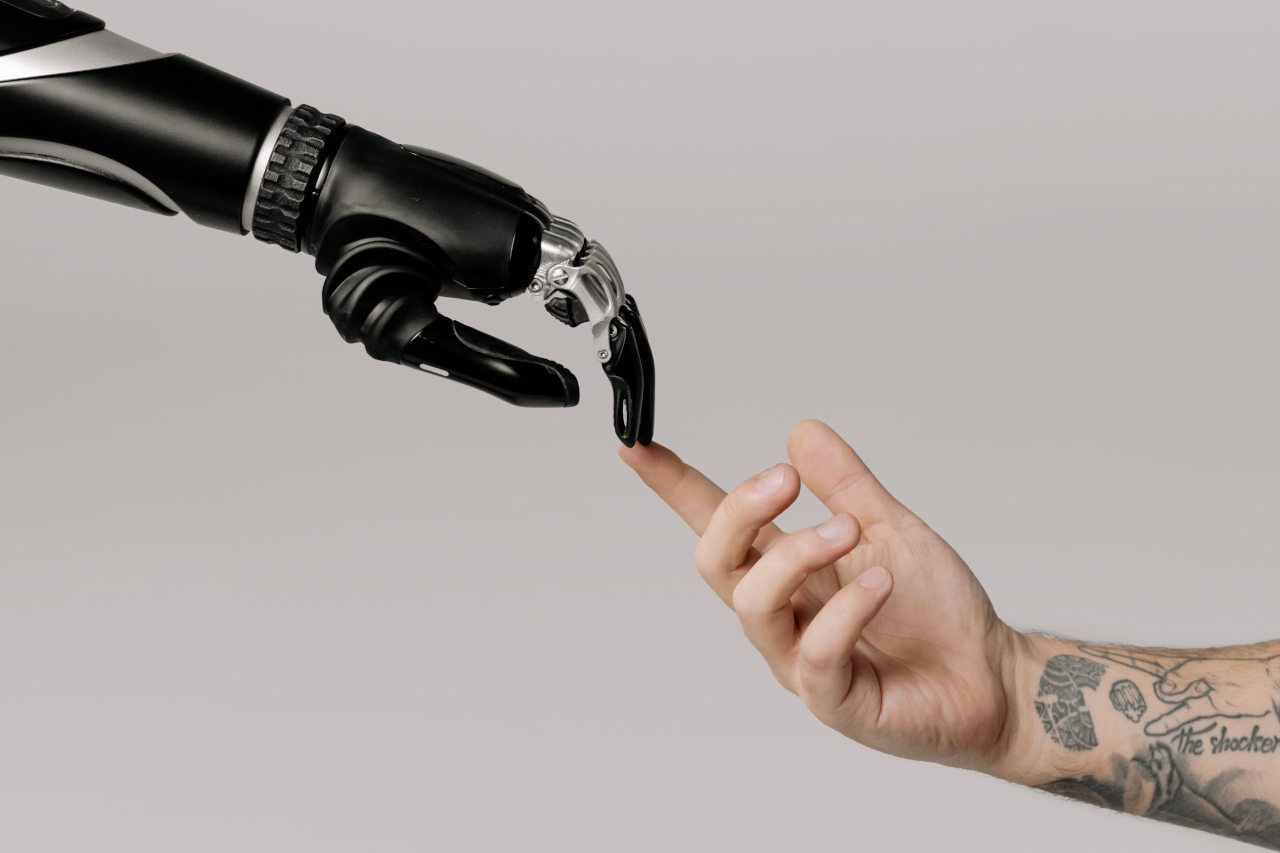 Robot finger touching human finger with tattoo on arm